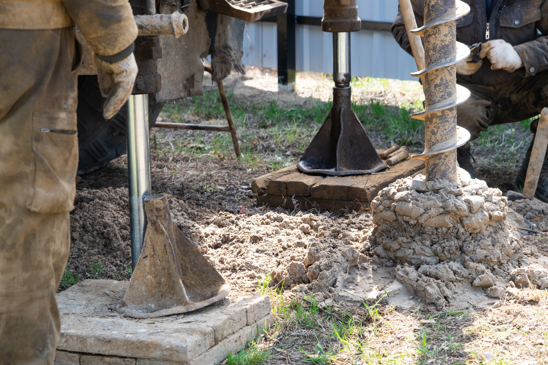 Team of workers with drilling rig on car are drilling artesian well for water in ground. Insertion of metal casing pipe into ground, installation of individual drinking supply, June 28, 2022, Russia,