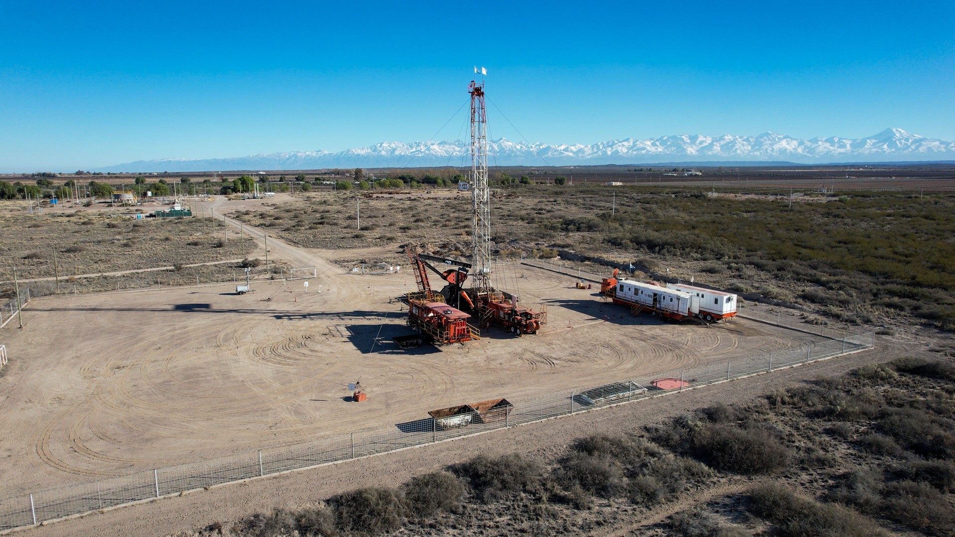 Aerial view of drilling rig. Andes Nevada mountain range background.